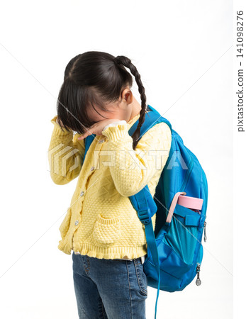Asian schoolgirl with backpack showing negative emotions, sad upset thinking crying child isolated on white background, education stress concept Asian schoolgirl with backpack showing negative emotions, sad upset thinking crying child isolated on white background, education stress concept 141098276