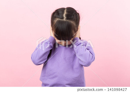 Asian little girl covering ears refusing to listen child ignoring concept Asian little girl covering ears refusing to listen child ignoring concept 141098427