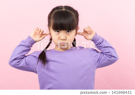 Asian little girl covering ears refusing to listen child ignoring concept Asian little girl covering ears refusing to listen child ignoring concept 141098431