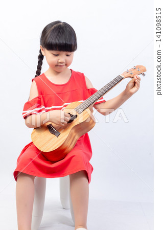 Asian little girl playing ukulele, learning music and fun instrument practice Asian little girl playing ukulele, learning music and fun instrument practice 141098515
