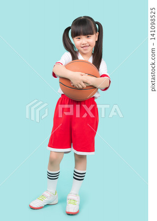 A full-body portrait of an Asian girl holding a basketball.kids sports and outdoor activity concept A full-body portrait of an Asian girl holding a basketball.kids sports and outdoor activity concept 141098525