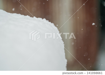 Heavy snow piled up in a round, dome shape on the roof of a car parked in the yard. Heavy snow piled up in a round, dome shape on the roof of a car parked in the yard. 141098661