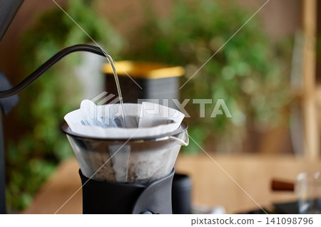 Pouring hot water into coffee filter for pour over coffee Pouring hot water into coffee filter for pour over coffee 141098796