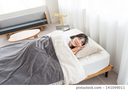 A young woman sleeping in bed A young woman sleeping in bed 141099011