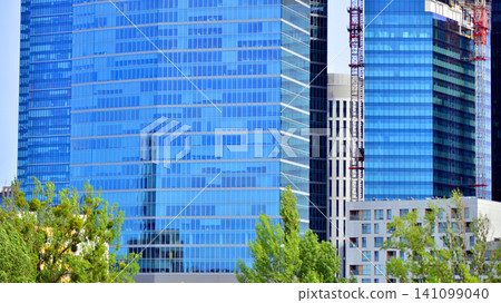 Building surrounded with green trees.  Eco-friendly building. Sustainable architecture of city reducing heat carbon dioxide modern city environment. 141099040