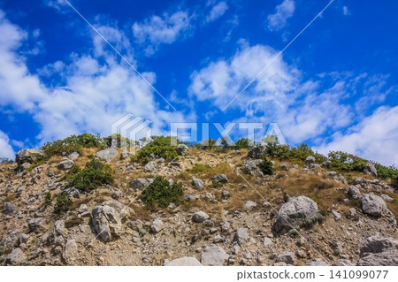 Rocky climb up the mountain and blue sky with clouds. Rocky climb up the mountain and blue sky with clouds. 141099077
