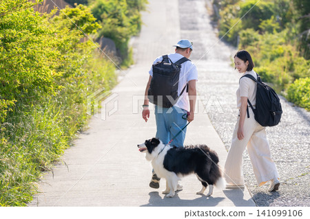 一對夫婦帶著他們的狗享受旅行,這是從背後拍攝的。 一對夫婦帶著他們的狗享受旅行,這是從背後拍攝的。 141099106