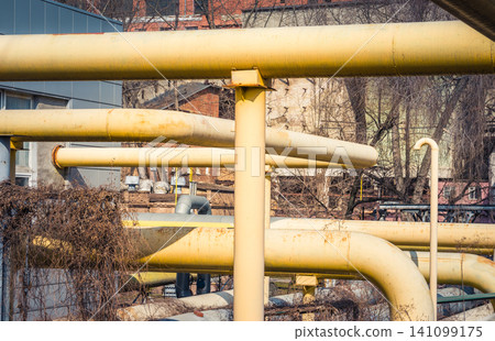 Large old pipes at the thermal station. Hot water distribution tubes from the heating system in a factory. 141099175