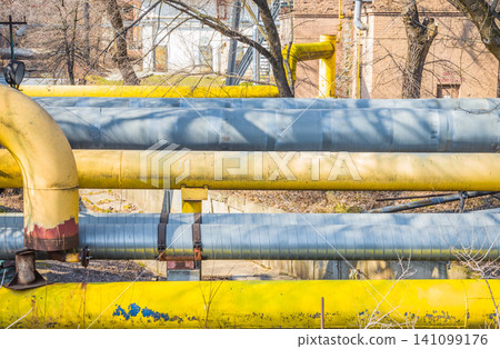 Large old pipes at the thermal station. Hot water distribution tubes from the heating system in a factory. 141099176