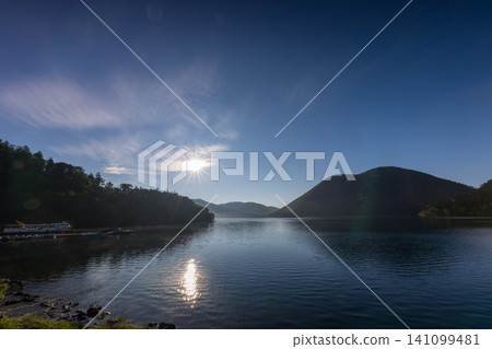 北海道鹿別湖清晨:寧靜的湖面和蔚藍的天空構成了一幅美麗的畫卷。 北海道鹿別湖清晨:寧靜的湖面和蔚藍的天空構成了一幅美麗的畫卷。 141099481