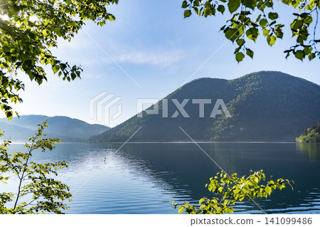 A refreshing morning at Lake Shikaribetsu in Hokkaido: A tranquil scene of the lake and blue sky. A refreshing morning at Lake Shikaribetsu in Hokkaido: A tranquil scene of the lake and blue sky. 141099486