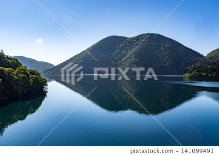 A refreshing morning at Lake Shikaribetsu in Hokkaido: A tranquil scene of the lake and blue sky. 141099491