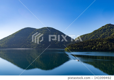 A refreshing morning at Lake Shikaribetsu in Hokkaido: A tranquil scene of the lake and blue sky. A refreshing morning at Lake Shikaribetsu in Hokkaido: A tranquil scene of the lake and blue sky. 141099492