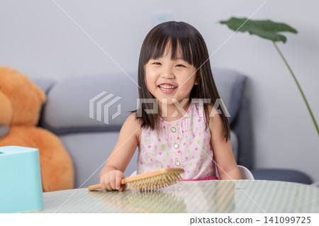 Little Asian Girl Brushing Hair at Home, Child Self Care Routine and Daily Hygiene Concept Little Asian Girl Brushing Hair at Home, Child Self Care Routine and Daily Hygiene Concept 141099725