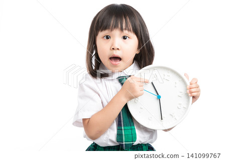 Surprised school girl holding a white clock, concept of being late or time management. Surprised school girl holding a white clock, concept of being late or time management. 141099767