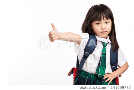 A confident little girl wearing a school uniform and backpack showing a thumbs-up sign on a white background. A confident little girl wearing a school uniform and backpack showing a thumbs-up sign on a white background. 141099773