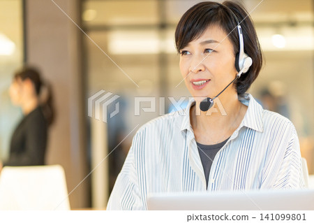 A smiling senior female operator using a computer. 141099801