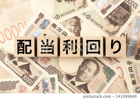A block with "Dividend Yield" written on it and lots of 10,000 yen bills. A block with "Dividend Yield" written on it and lots of 10,000 yen bills. 141099840