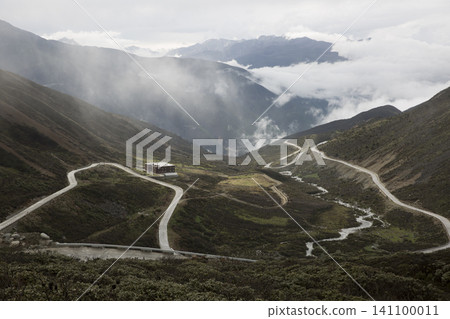 Misty Mountain Road Winding Through Remote Alpine Valley Misty Mountain Road Winding Through Remote Alpine Valley 141100011