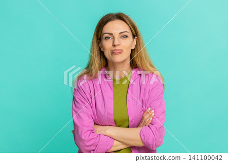 Woman sticking out tongue teasing with playful expression showing fun joke or mild mocking gesture Woman sticking out tongue teasing with playful expression showing fun joke or mild mocking gesture 141100042