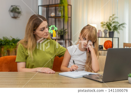 Mother daughter laptop online lesson tired girl study mother encourage support guide calm at table Mother daughter laptop online lesson tired girl study mother encourage support guide calm at table 141100076
