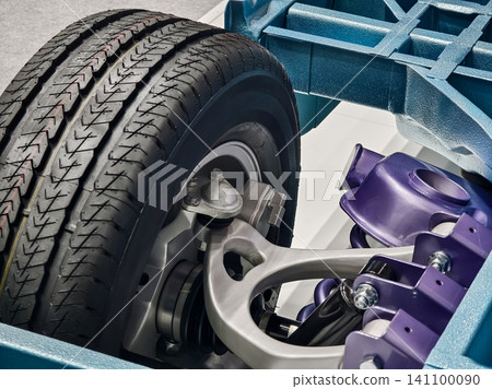 Details of a car chassis with a close view of the tire and suspension components showing construction and design choices in auto industry Details of a car chassis with a close view of the tire and suspension components showing construction and design choices in auto industry 141100090