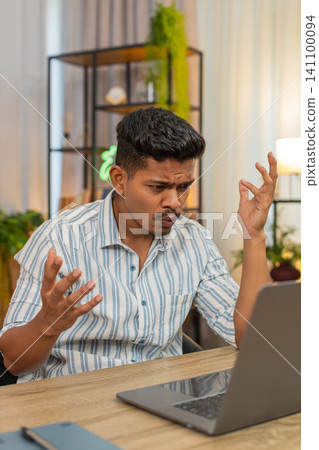 Indian man reads bad project news on laptop sighs feels defeat loss failure after overdue deadline Indian man reads bad project news on laptop sighs feels defeat loss failure after overdue deadline 141100094