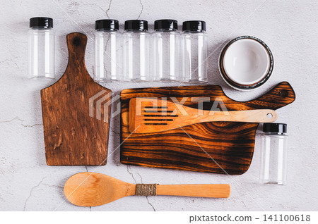 Kitchen set of wooden cutting boards, spatulas, bowls and spice bottles on the table top view Kitchen set of wooden cutting boards, spatulas, bowls and spice bottles on the table top view 141100618