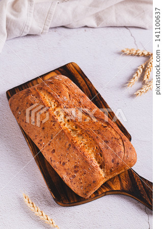 Homemade ciabatta made from white grain flour on a wooden board on the table vertical view Homemade ciabatta made from white grain flour on a wooden board on the table vertical view 141100637