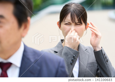 亞洲女子因氣味難聞而捏住鼻子。 141100683