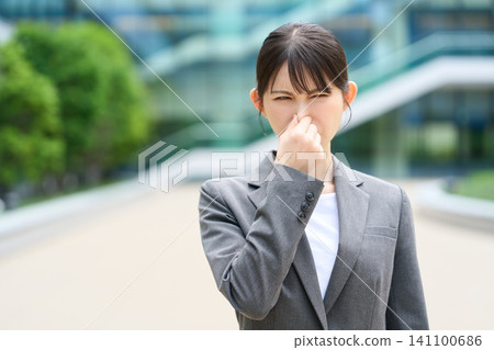 Asian woman pinches her nose because of the smell. Asian woman pinches her nose because of the smell. 141100686