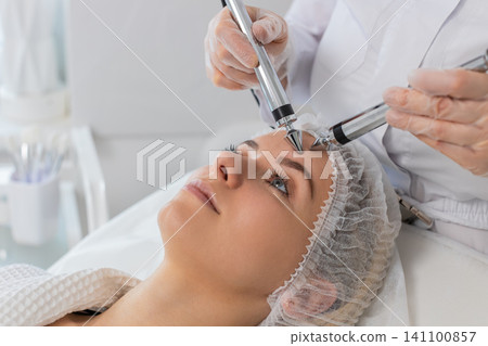 Adult woman receives forehead microcurrent skin therapy in cosmetology clinic rejuvenation session Adult woman receives forehead microcurrent skin therapy in cosmetology clinic rejuvenation session 141100857