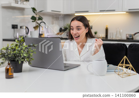 Young woman celebrates discount success promo code works smiles big happy reaction online shopping Young woman celebrates discount success promo code works smiles big happy reaction online shopping 141100860