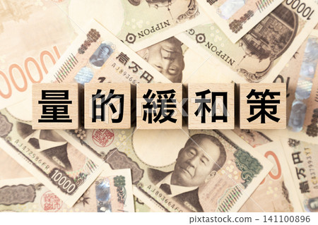 A block with the words "Quantitative Easing" written on it, and lots of 10,000 yen bills. A block with the words "Quantitative Easing" written on it, and lots of 10,000 yen bills. 141100896