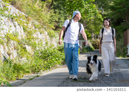 A young couple traveling with their pet, a Border Collie. A young couple traveling with their pet, a Border Collie. 141101011