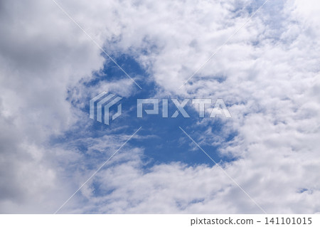 White clouds surround a large blue patch in the summer sky, forming a triangle. White clouds surround a large blue patch in the summer sky, forming a triangle. 141101015