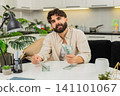 Indian man counting dollar cash saving in neat stacks planning budget dreaming about future purchase 141101067