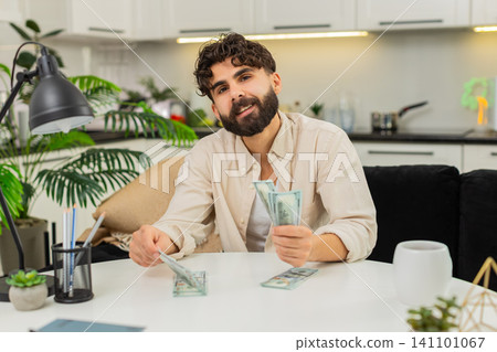 Indian man counting dollar cash saving in neat stacks planning budget dreaming about future purchase Indian man counting dollar cash saving in neat stacks planning budget dreaming about future purchase 141101067