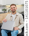 Young man closes laptop after tasks exhales with relief work finished calm relaxed mood success end 141101075