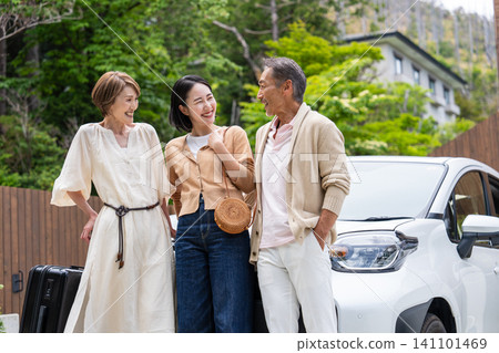 一對老年夫婦和他們的女兒一家人乘車旅行。 一對老年夫婦和他們的女兒一家人乘車旅行。 141101469