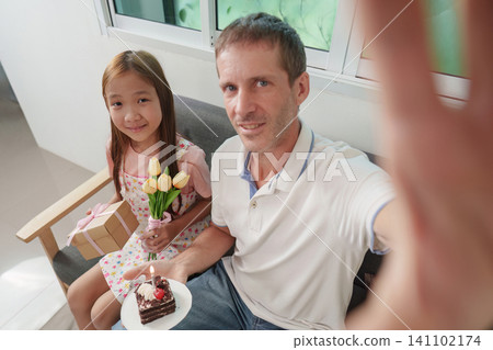 Father and daughter taking selfie during birthday celebration at home Father and daughter taking selfie during birthday celebration at home 141102174