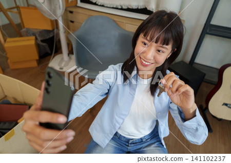 Asian woman taking selfie with key in new apartment for moving day Asian woman taking selfie with key in new apartment for moving day 141102237