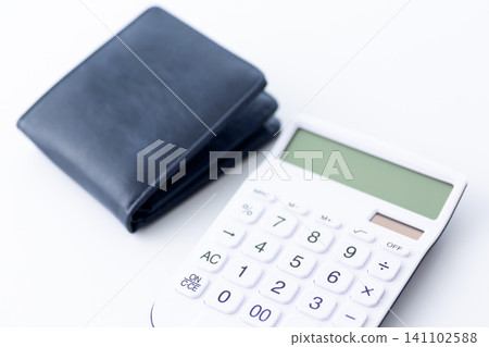 A navy blue bifold wallet and a calculator A navy blue bifold wallet and a calculator 141102588