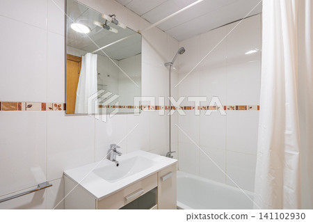Modern bathroom with a shower, white tiles, and a mirror. Features a sink and a bathtub. Clean and minimalistic design Modern bathroom with a shower, white tiles, and a mirror. Features a sink and a bathtub. Clean and minimalistic design 141102930