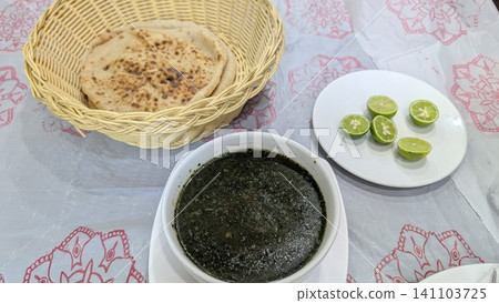 Molokhia and shrimp soup with cut limes and a basket of flatbread Molokhia and shrimp soup with cut limes and a basket of flatbread 141103725
