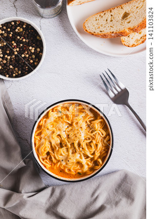 Delicious cheesy spicy ramen noodles in a bowl on the table top and vertical view Delicious cheesy spicy ramen noodles in a bowl on the table top and vertical view 141103824