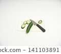 Cucumber sliced into rounds on a cutting board 141103891