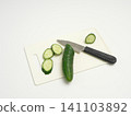 Cucumber sliced into rounds on a cutting board 141103892