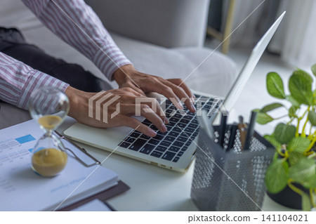 Business Typing on Laptop with Hourglass on Table. Time Management Concept. 141104021