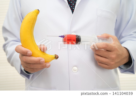 Male doctor making an injection to a banana with a syringe, penis health. Male doctor making an injection to a banana with a syringe, penis health. 141104039